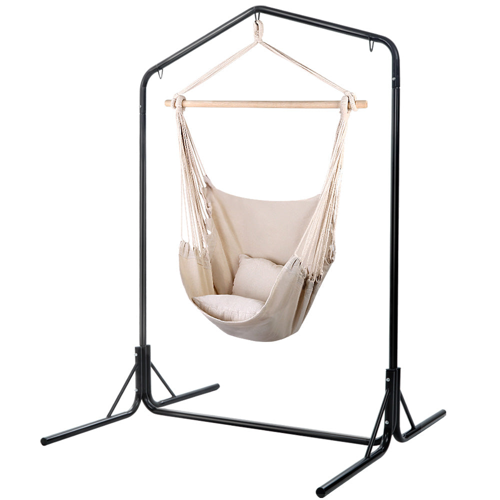Cream hanging chair with cushions suspended from the included black steel stand.