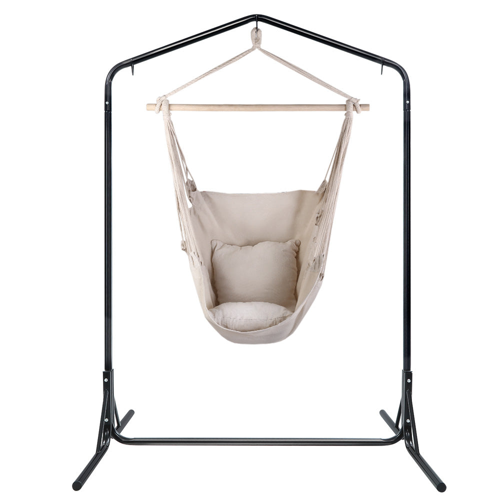Front view of the cream hanging chair suspended from its freestanding steel frame.