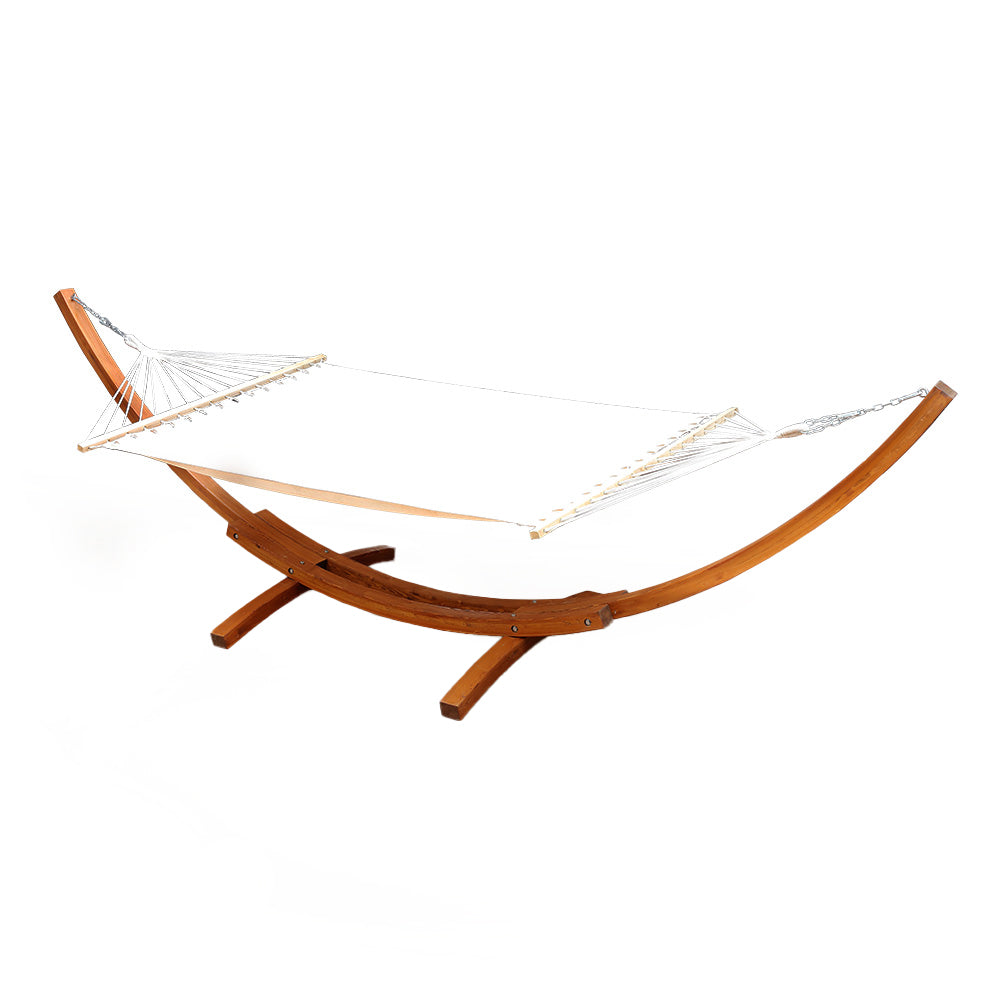 Cream double hammock with timber spreader bars on a curved timber stand.