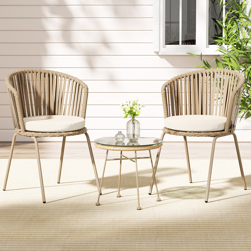 Two cushioned rope chairs and a round table on a covered patio; styling accessories not included.